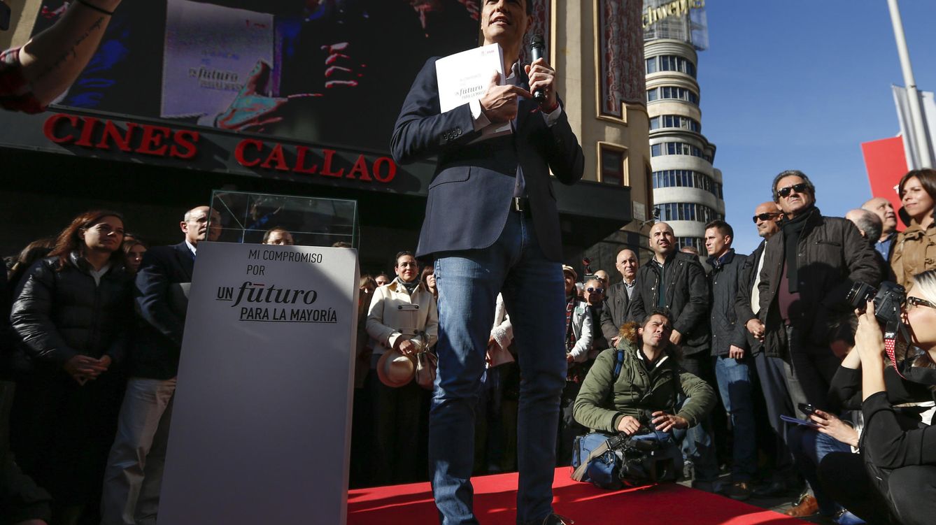 Foto: Pedro Sánchez, micrófono en mano, exhibe el programa del PSOE, tras firmarlo como contrato con los ciudadanos en la plaza del Callao de Madrid, este 9 de diciembre. (EFE)