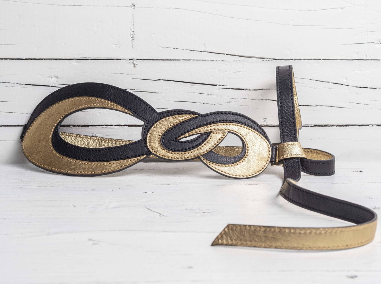 Cinturón 'Infinity Gold' en piel de becerro negro y oro, un valor seguro para rematar cualquier look.