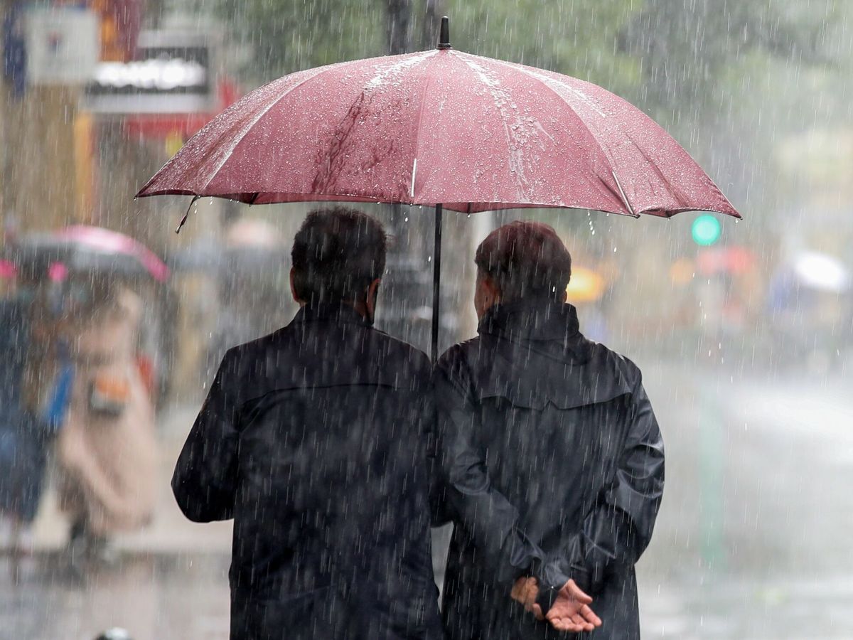 Foto: Unos paseantes se protegen con un paraguas. (EFE/Juan Herrero)