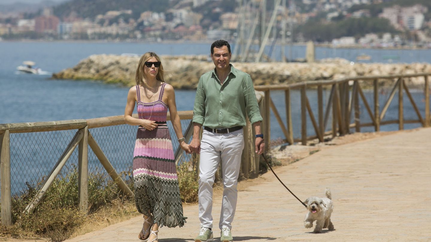 Manuela Villena y Juanma Moreno, paseando a su perro en la jornada de reflexión. (EFE)