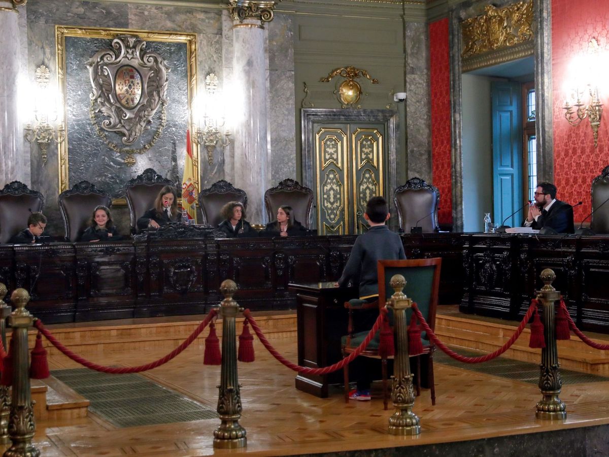 Foto: Un grupo de niños ha ocupado los puestos destinados a los magistrados en una de las salas del Tribunal Supremo durante la jornada de puertas abiertas. (EFE)