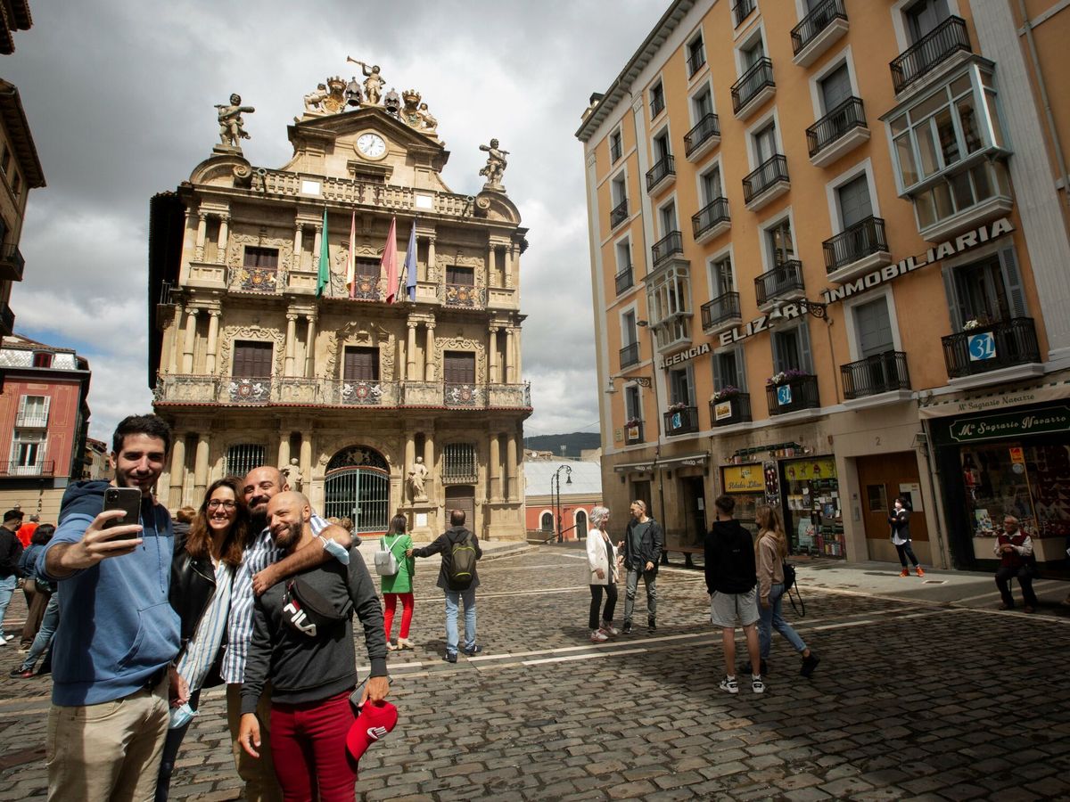 Foto: Un grupo de turistas se hacen una fotografía ante la fahada del Ayuntamiento de Pamplona. (EFE)