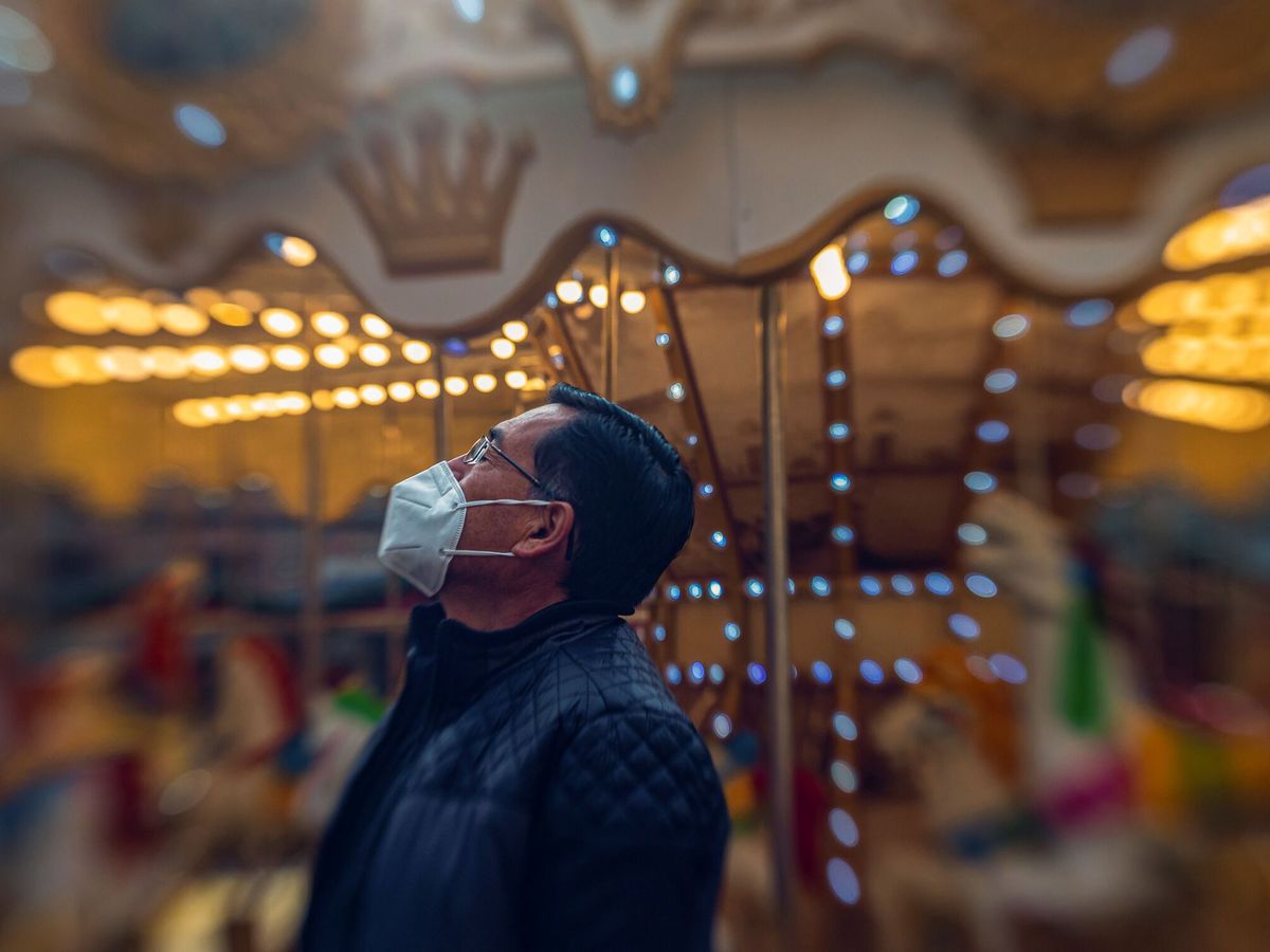 Foto: Un hombre con mascarilla junto a un tiovivo en Toledo. (EFE/Ángeles Visdómine)