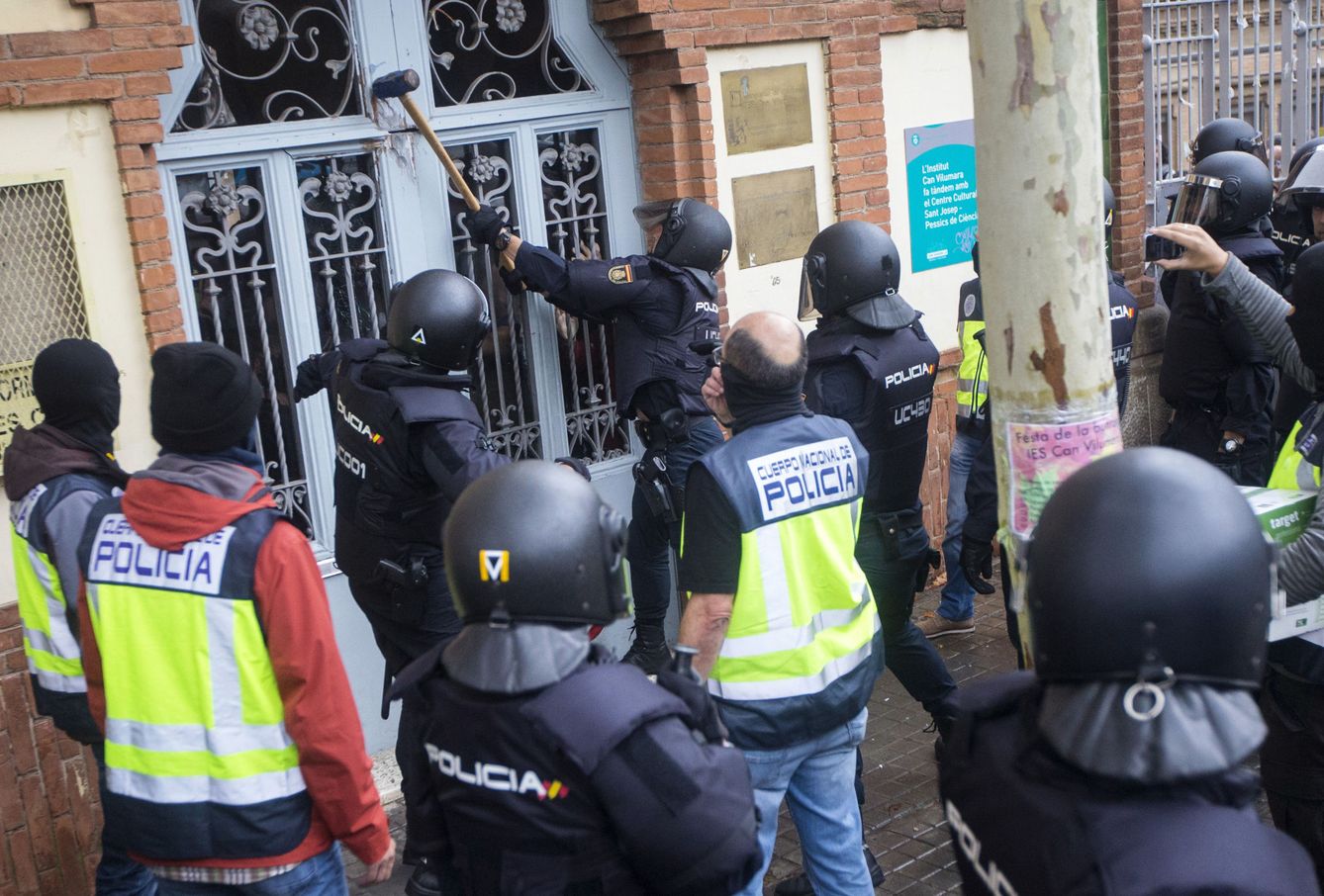 Agentes antidisturbios de la Policía Nacional a las puertas del Instituto Can Vilumara de L'Hospitalet de Llobregat. (EFE Quique García)