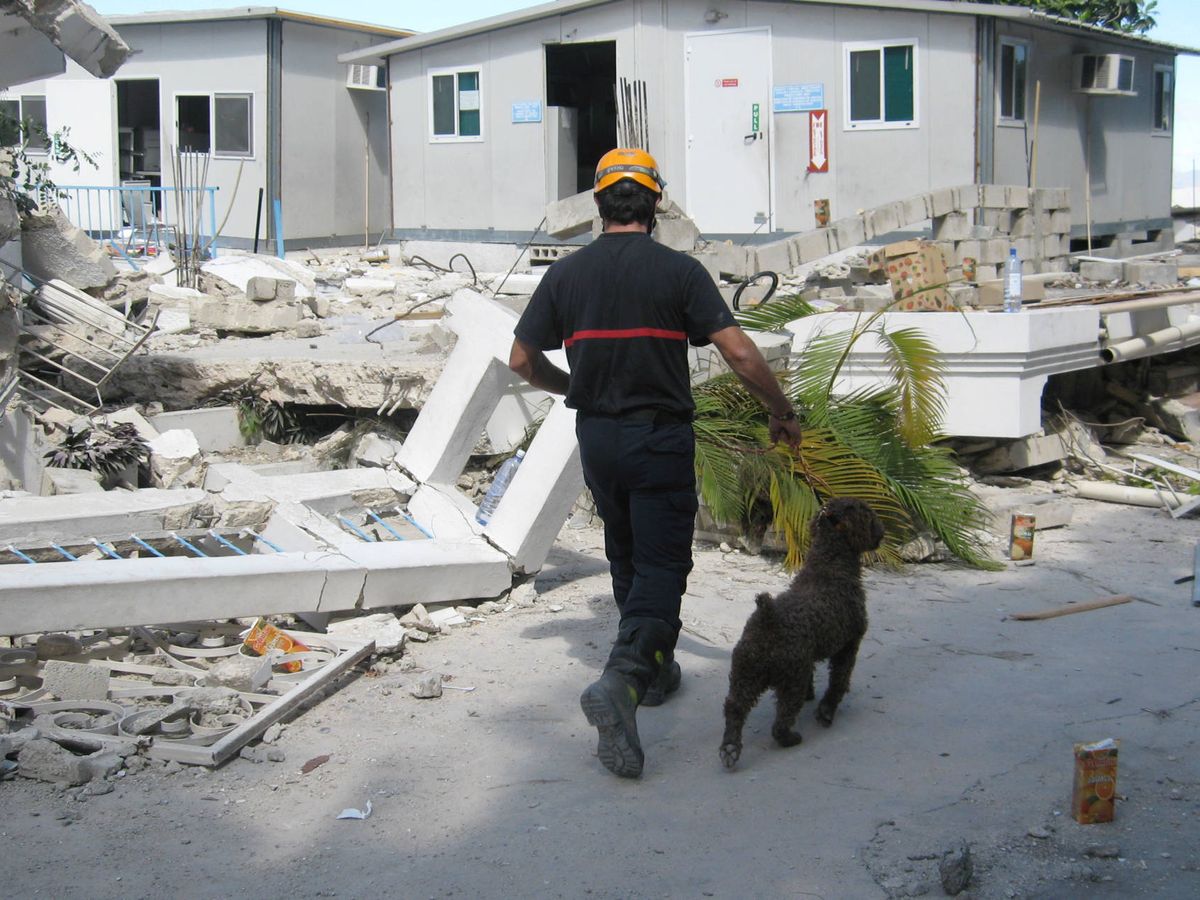 Foto: Uno de los bomberos de la ONG, con uno de los perros adiestrados, en el terremoto de Haití. (Foto cedida)