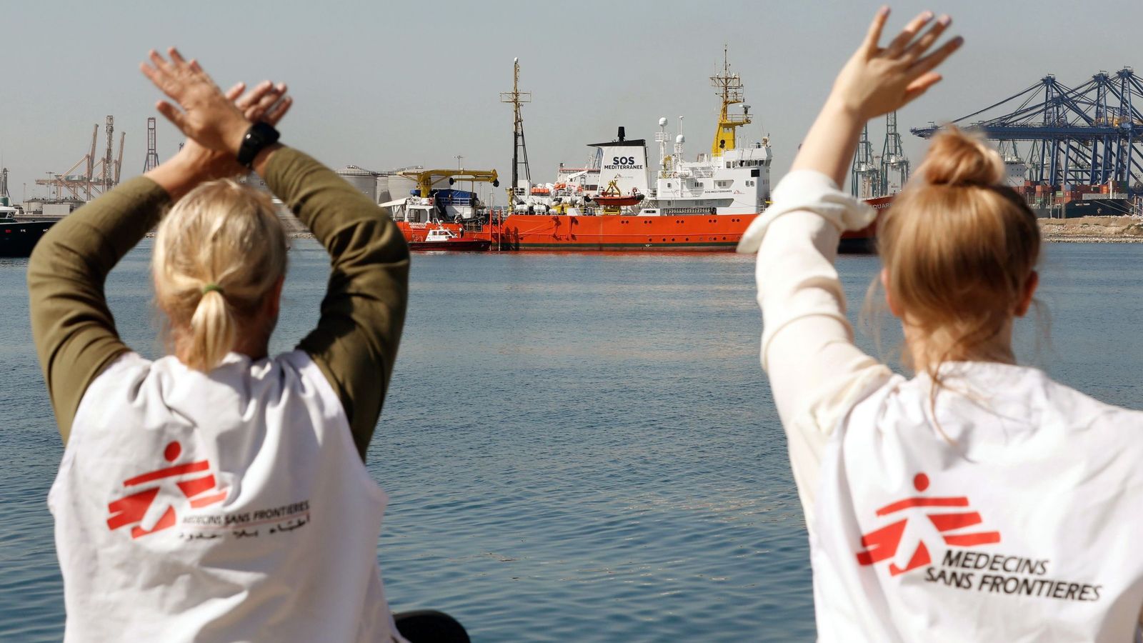 Foto: Dos miembros de Médicos sin fronteras dan la bienvenida al Aquarius en el puerto de Valencia. (EFE)