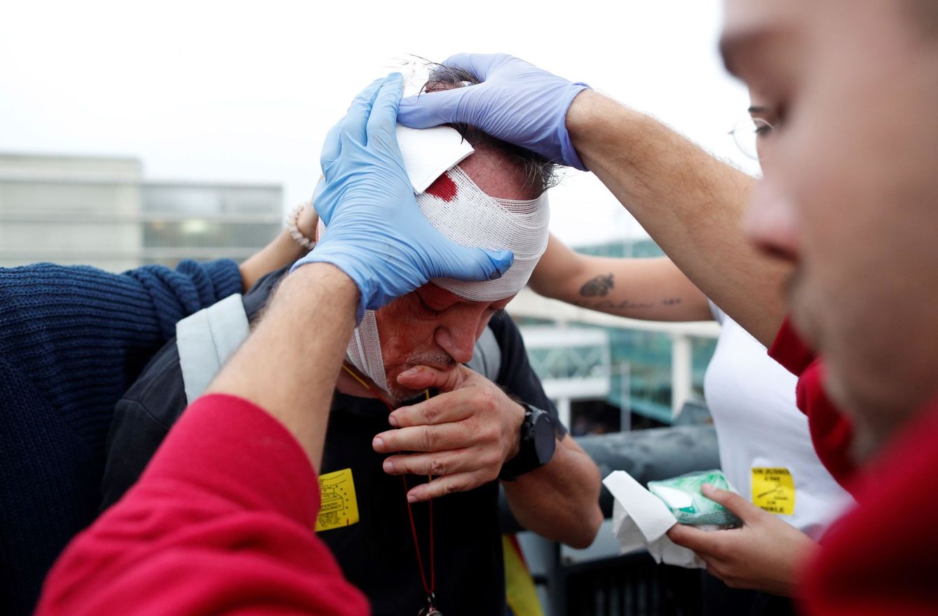 Un sanitario atiende a un manifestante herido después de las cargas de los Mossos. (EFE)
