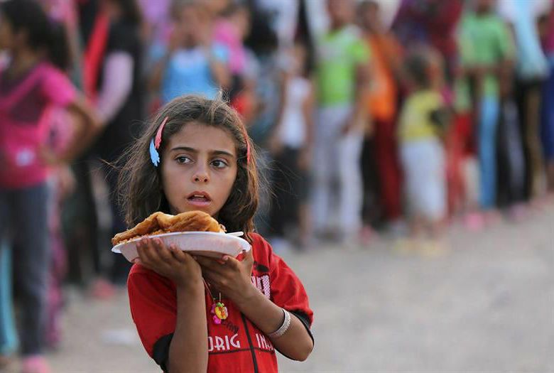 Una niña sostiene su comida en un campo de refugiados. (Efe)