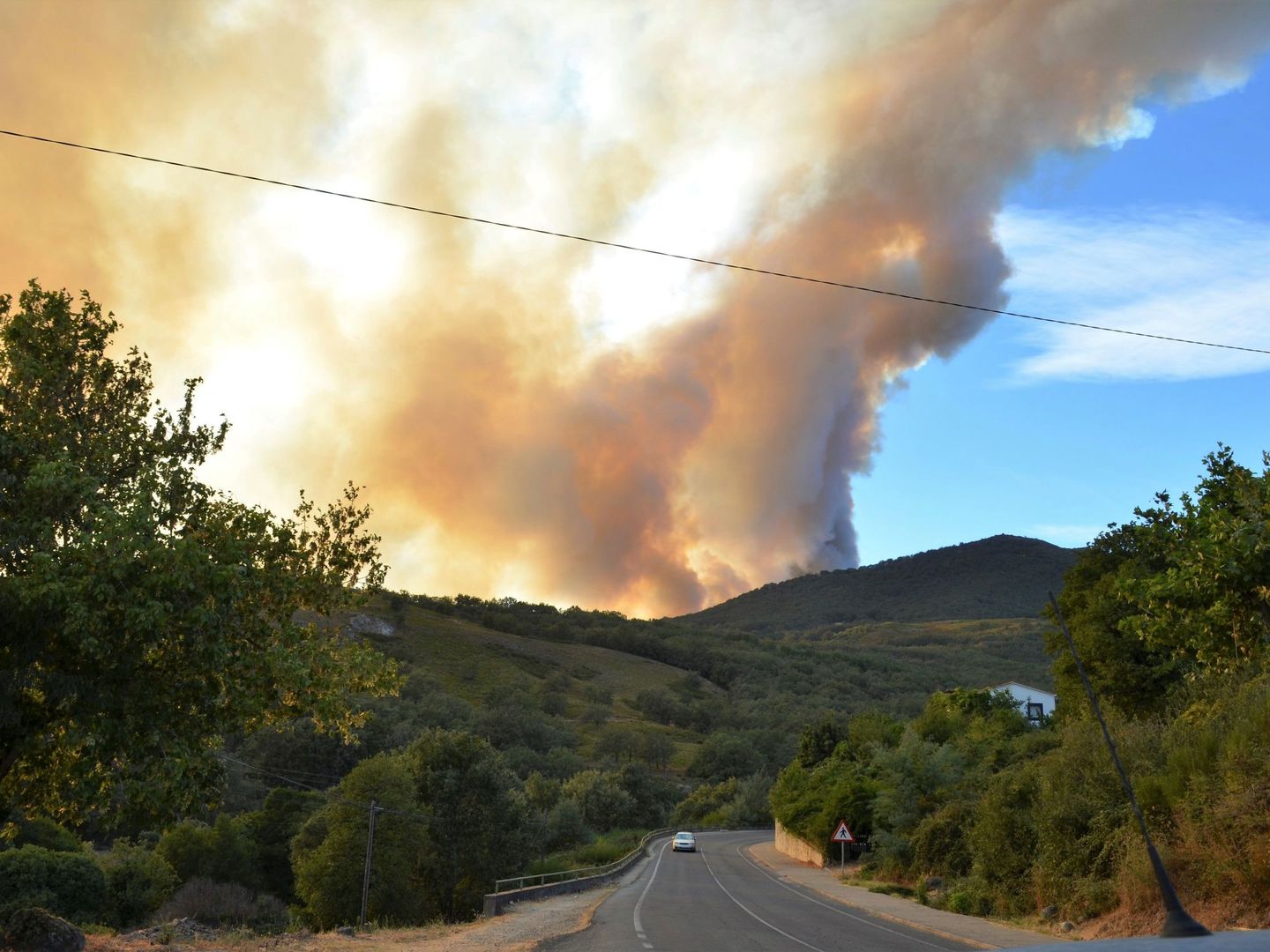 Medios aéreos y terrestres trabajan en la extinción de un incendio forestal declarado en el Valle del Jerte (Cáceres). (EFE)