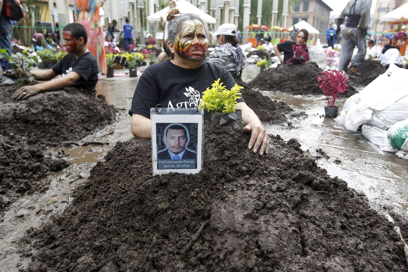 Activistas se entierran en falsas tumbas para protestar contra los desaparecidos de la Operación Orión, en Medellín, en octubre de 2015. (Reuters)