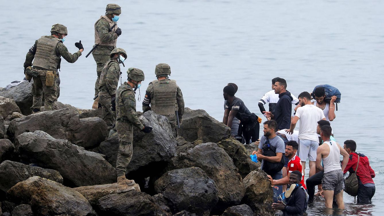 Foto: Miembros del Ejército con un grupo de inmigrantes en la Playa de El Tarajal. (Reuters)