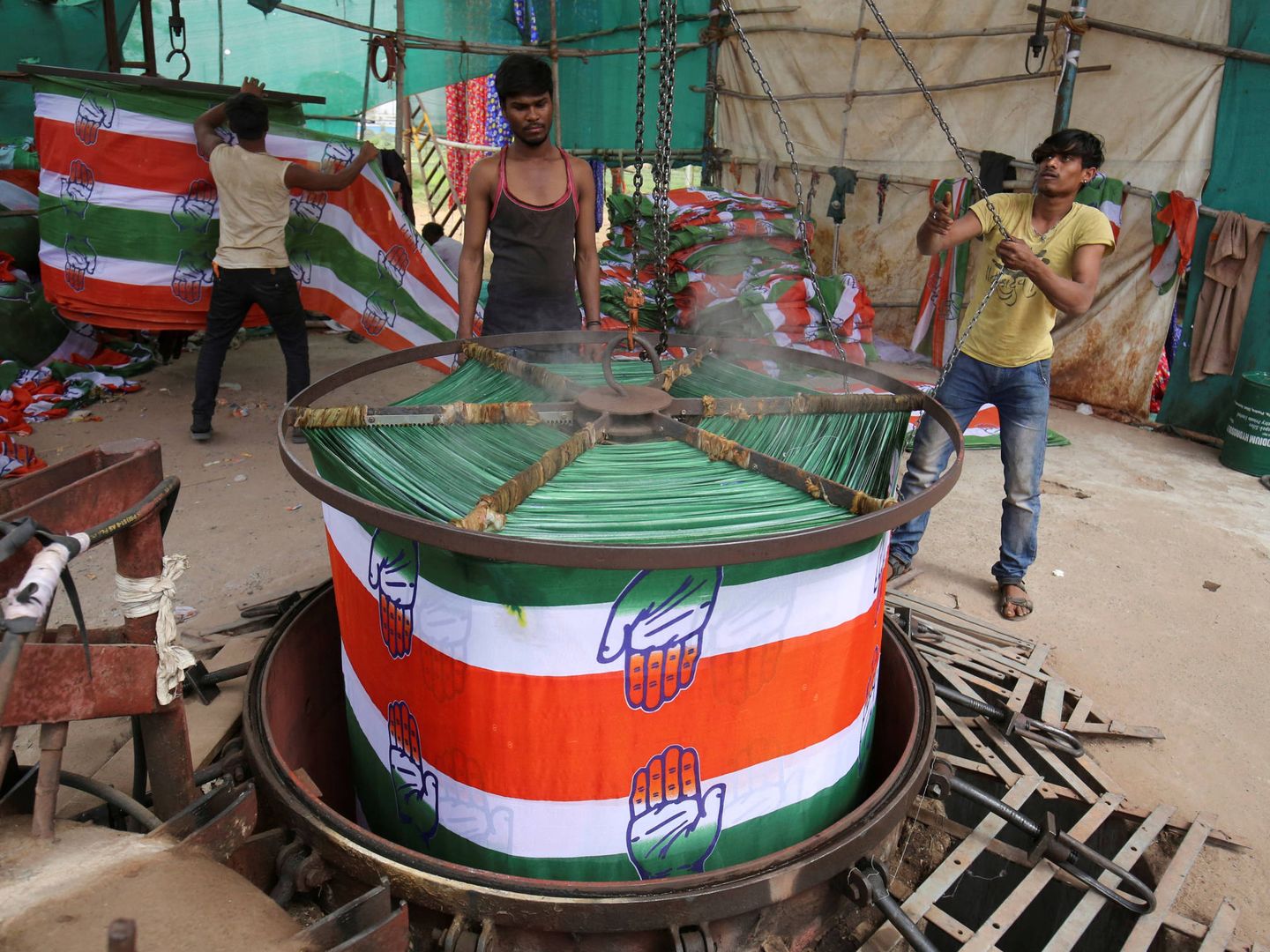 Un trabajador desenrolla un rollo de tela con propaganda electoral en una fábrica Ahmedabad, India. (Reuters)