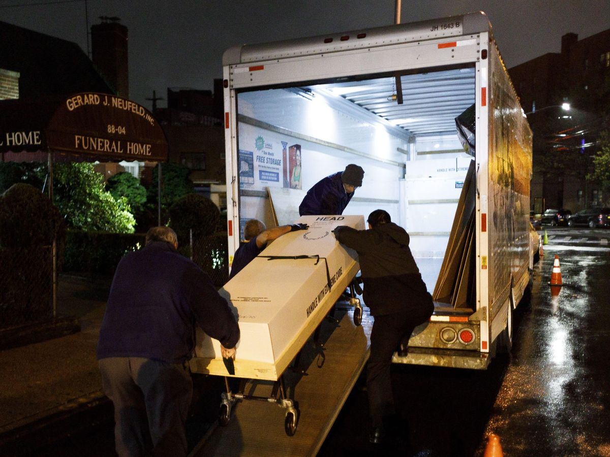 Foto: Carga de un fallecido por covid-19 en un camión refrigerado en Queens, NY, para ser cremado en Buffalio (EFE)