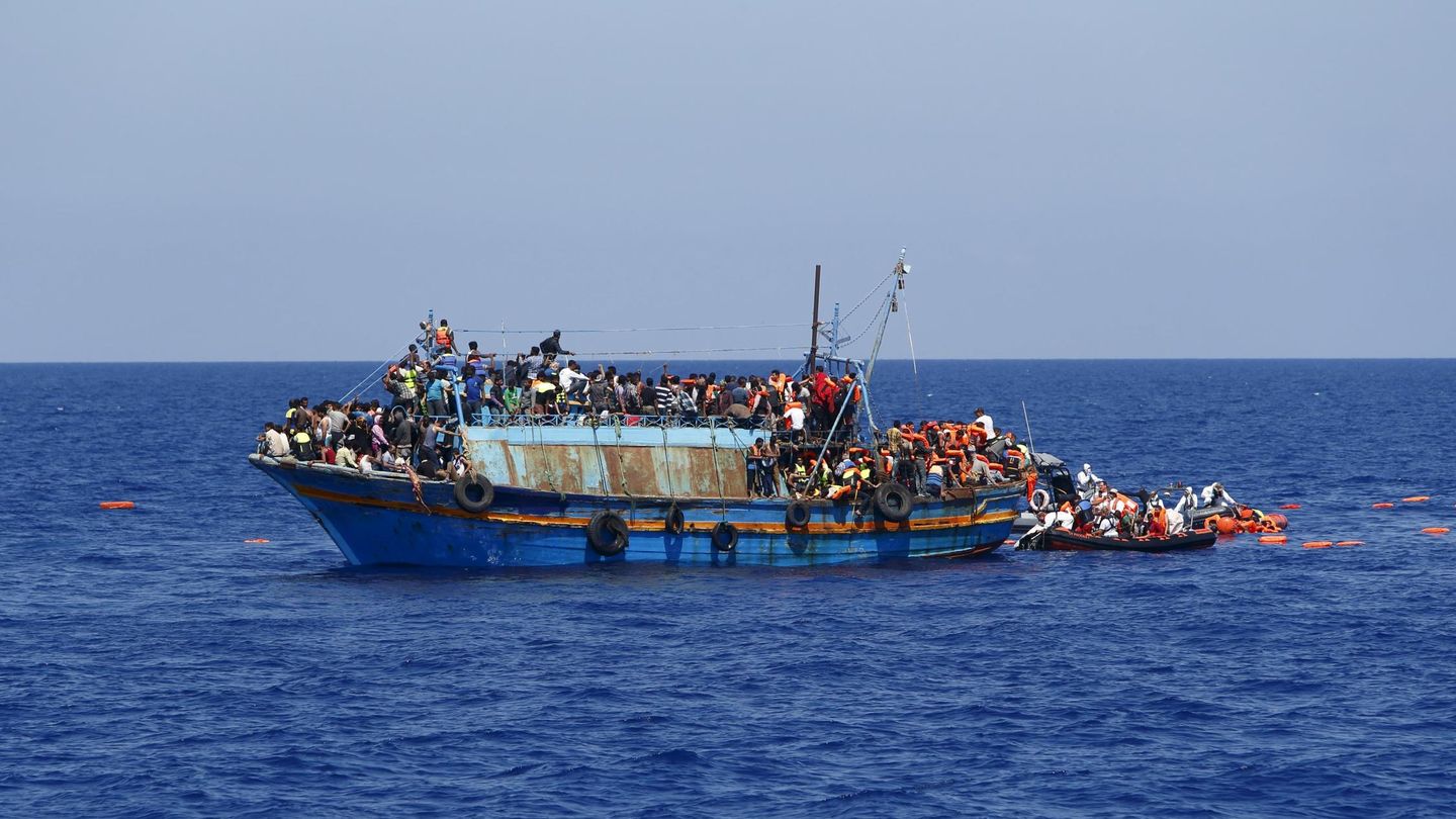 Inmigrantes en una patera a punto de volcar siendo rescatados frente a las costas de Libia. (Reuters)