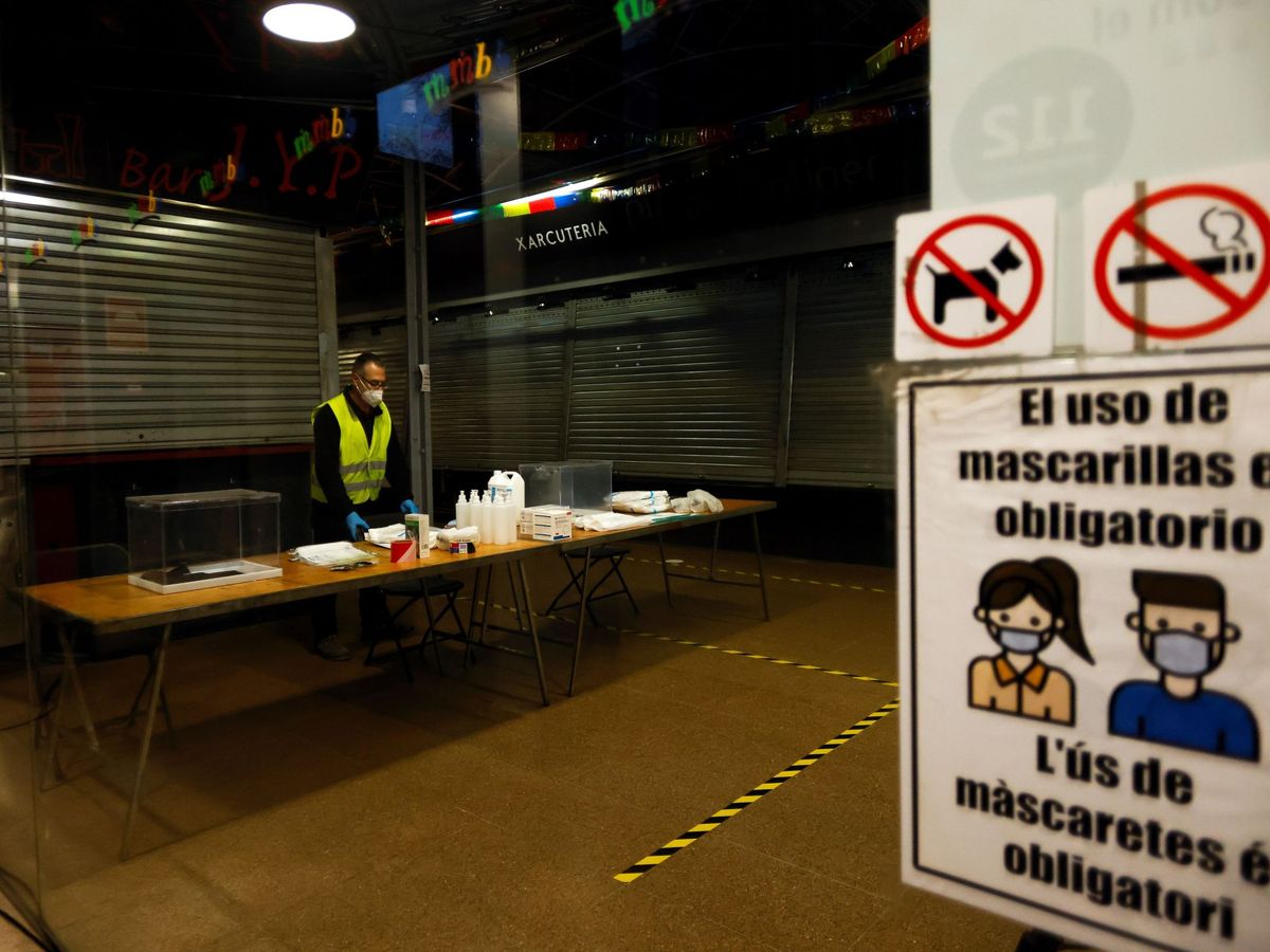 Foto: Un operario procede a colocar las mesas, cabinas y urnas en el Mercado del Ninot de Barcelona. (EFE)