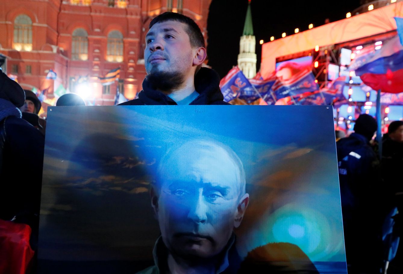 Un opositor a Putin sostiene un póster del presidente ruso en Moscú, el 18 de marzo de 2018. (Reuters)