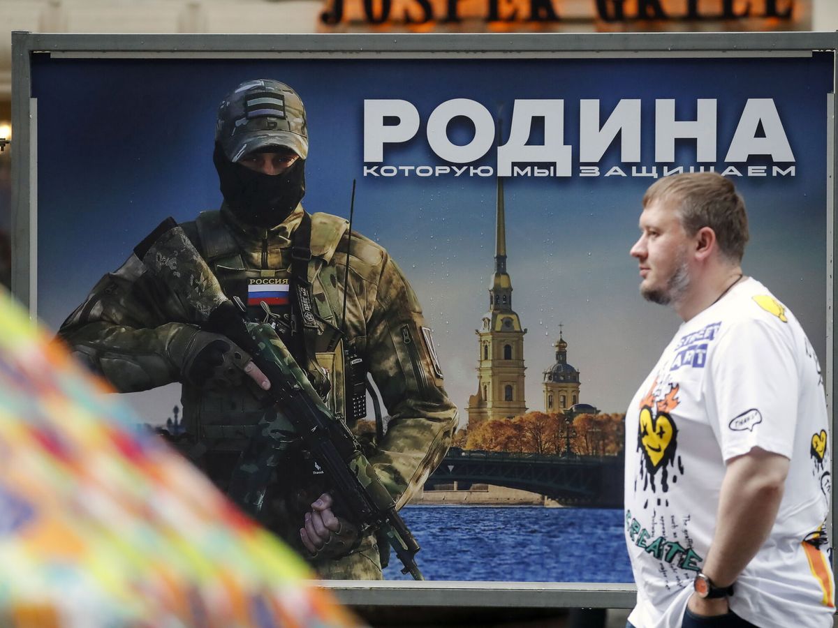Foto: Un hombre pasa junto a una valla publicitaria en la que aparece un militar ruso y se lee "Defendemos la patria". (EFE / Anatoly Maltsev)