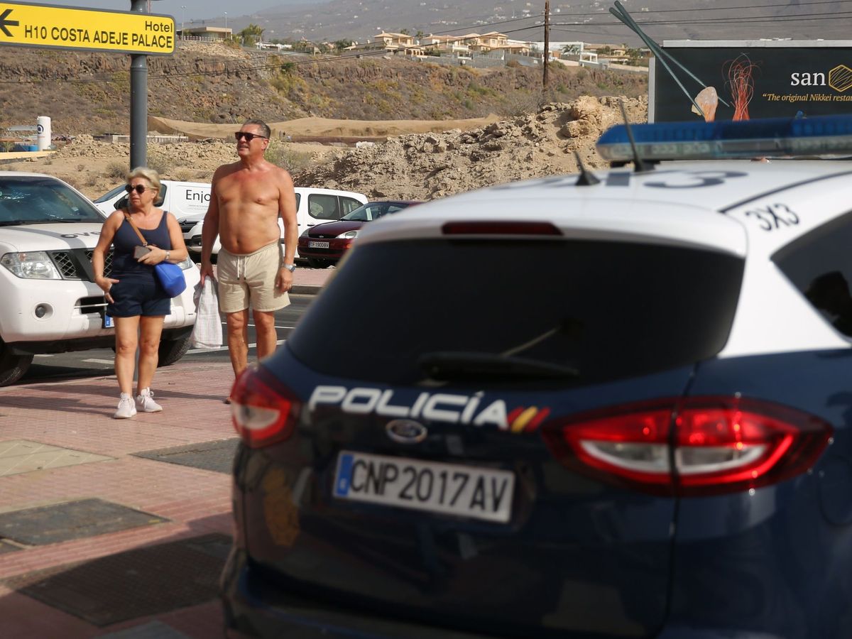 Foto: Dos turistas observan los controles de seguridad en las cercanías del hotel donde se hospedaban los cuatro de los afectados en España por coronavirus en Tenerife. (EFE)