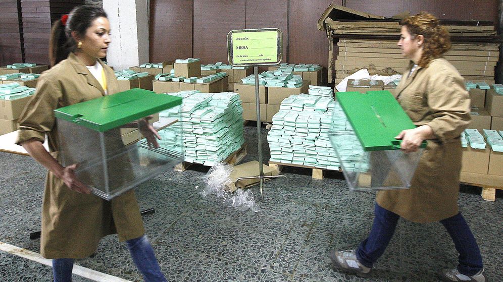 Foto: Dos trabajadoras del Ayuntamiento de Sevilla transportan urnas electorales. (EFE/Eduardo Abad)