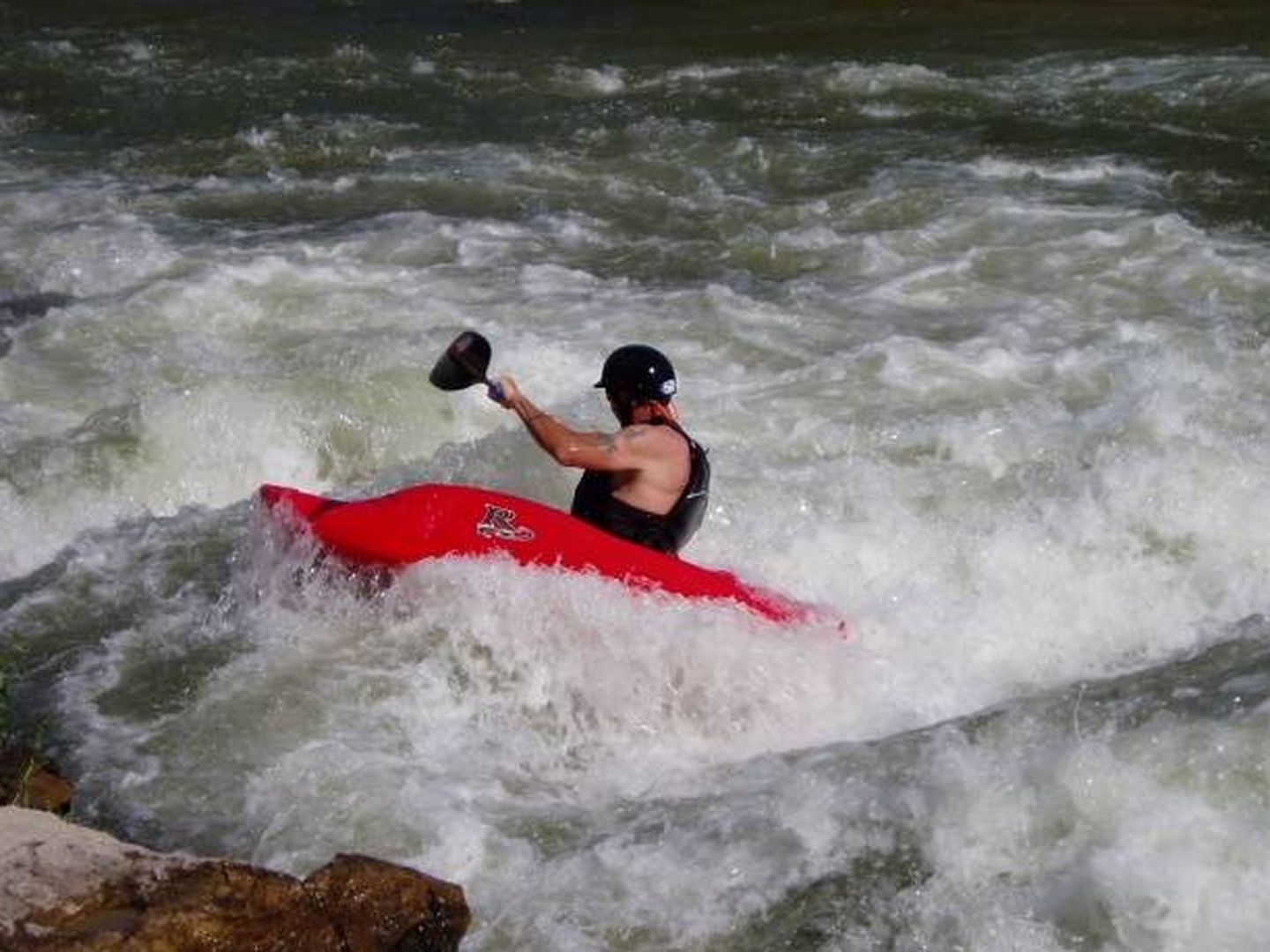 Deportista en kayak en una zona de aguas bravas. 