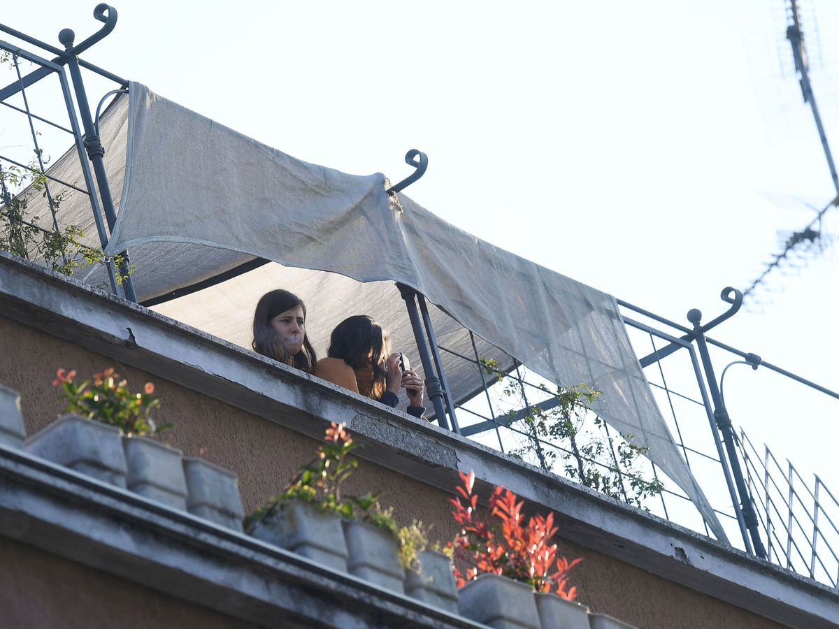 Foto: Una mujer se asoma a un balcón en Milán. (Reuters)