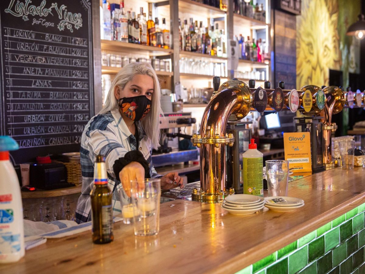 Foto: Una camarera recoge vasos en una barra de bar en Logroño, antes del cierre de la hostelería. (EFE)