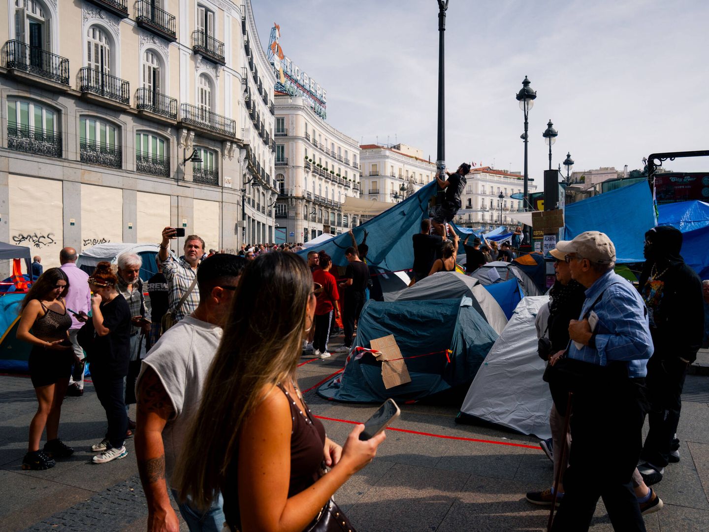 Transeúntes en la acampada por la vivienda, ayer a mediodía. (P. P.)