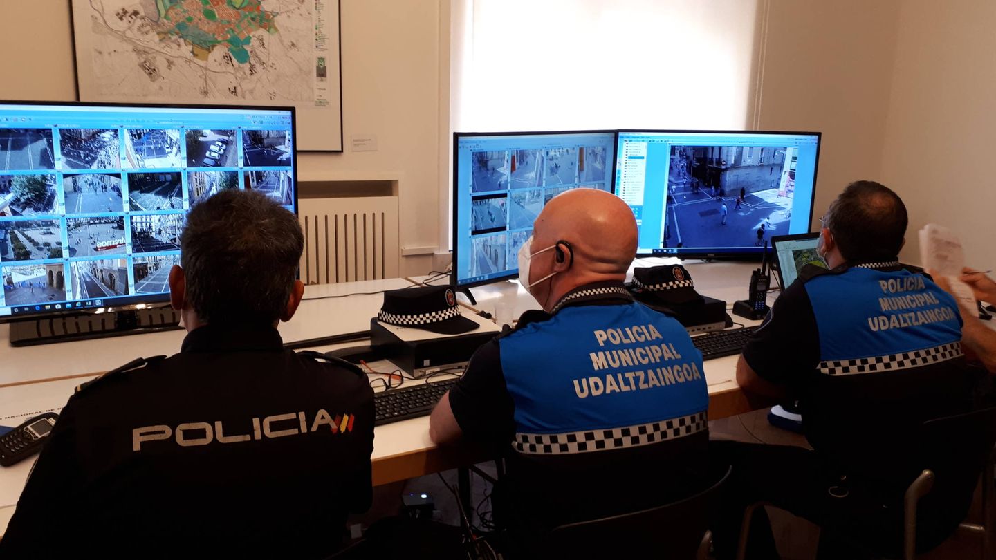 Efectivos policiales miran la cámaras en la sala de control del Ayuntamiento de Pamplona. (J.M.A.)