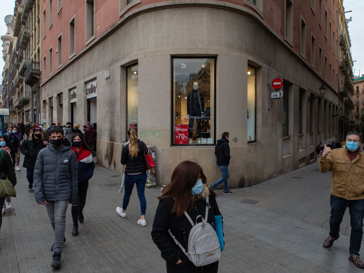 Foto: Varios transeúntes pasan ante un comercio del centro de Barcelona. (EFE)