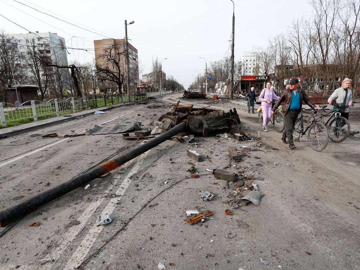 Foto: Civiles junto a un tanque destruido en Mariúpol. (Reuters/Alexander Ermochenko)