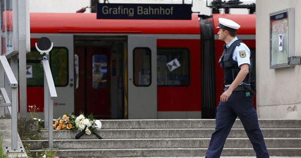 Foto: Un policía pasa delante de unas flores depositadas tras un ataque a cuchillo en un tren al sureste de Múnich, en mayo de 2016. (Reuters)