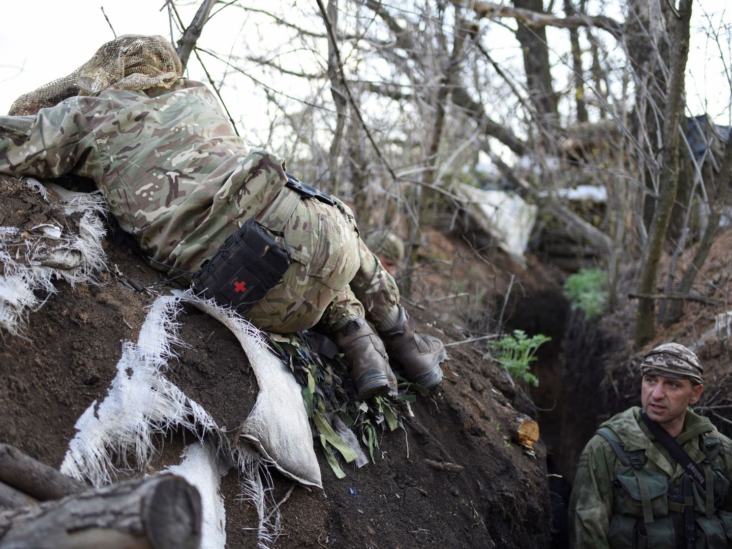 Un soldado ucraniano observa desde unos prismáticos mientras otro monta guardia a sus espaldas, en Lugansk, Ucrania. (EFE)