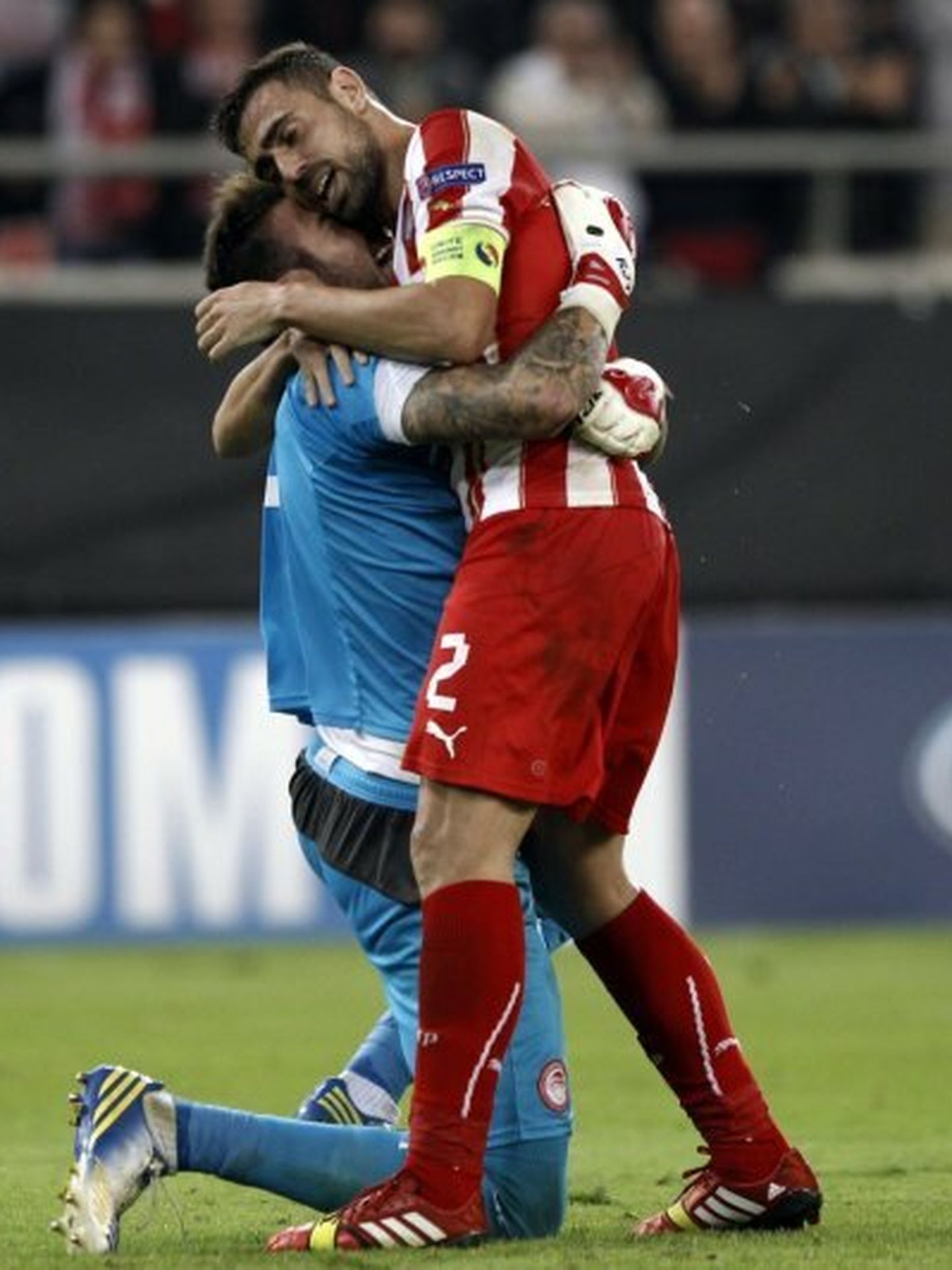 Olympiakos piraeus' goalkeeper roberto and his teamate giannis maniatis celebrate after beating benfica during their champions league soccer match in piraeus