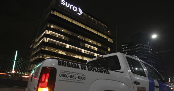 Foto: Fotografía de un vehículo de la Brigada de explosivos frente al edificio donde se encuentran las oficinas de la empresa española Indra, donde explotó el paquete. (EFE)