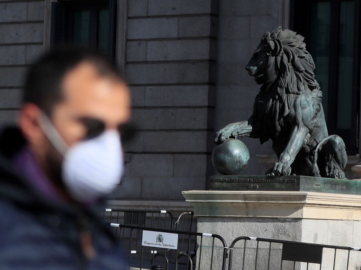 Foto: Un hombre con mascarilla pasea frente al Congreso de los Diputados en Madrid. (EFE)