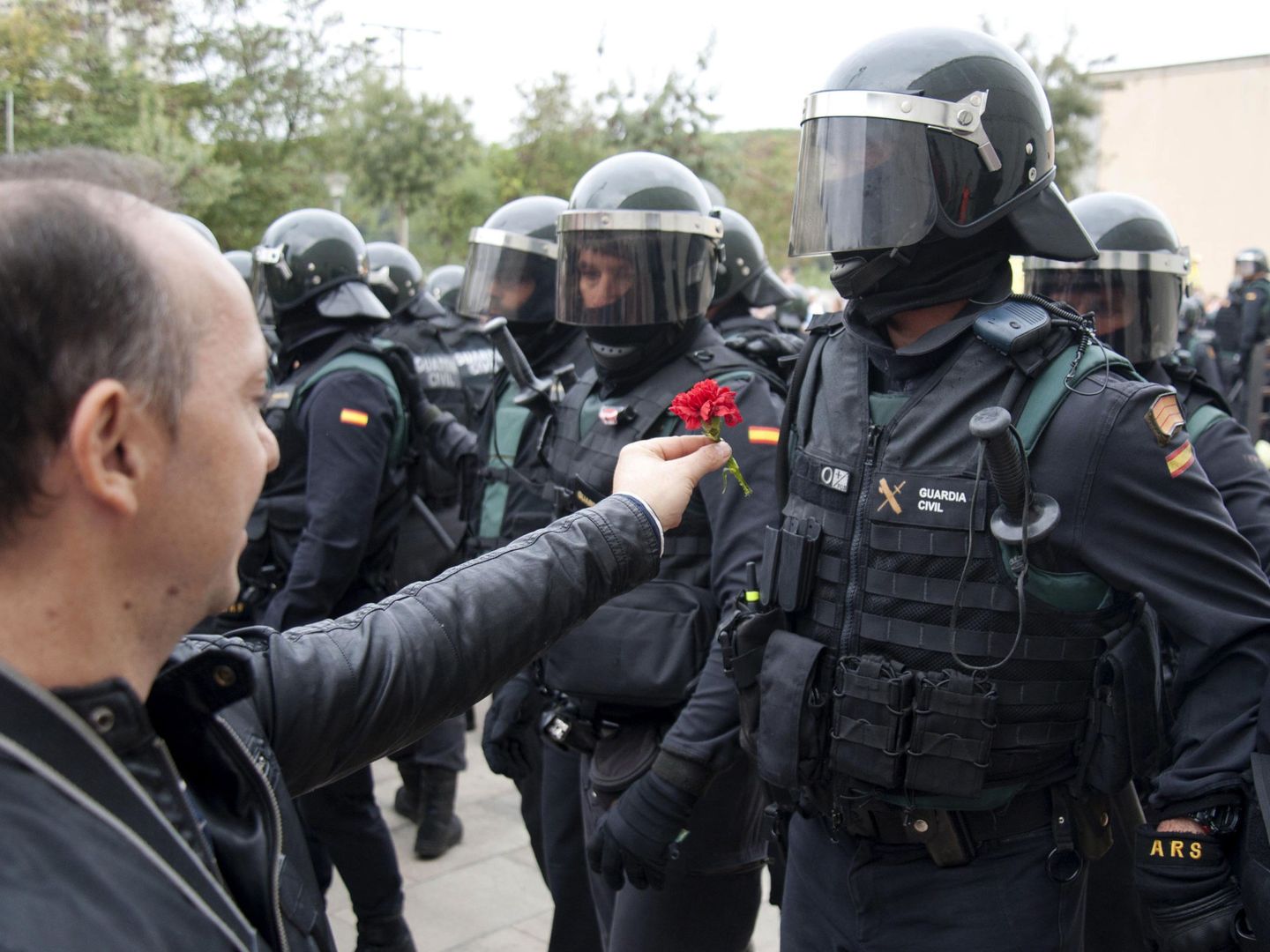 Un hombre ofrece un clavel a un agente de la Guardia Civil en el centro de votación de Sant Julià de Ramis (Girona). (EFE)