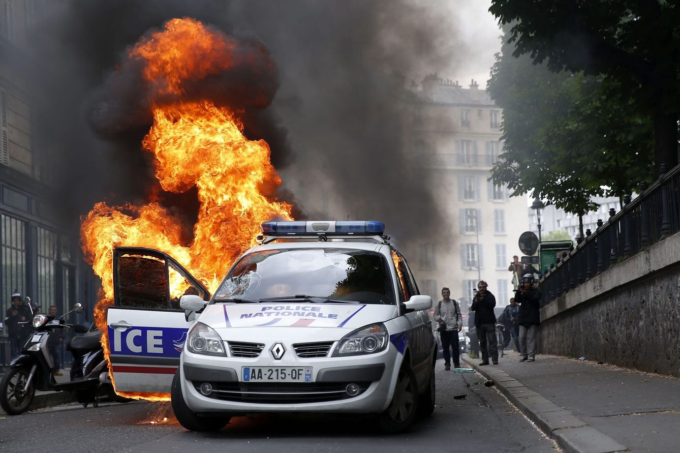 Un coche policial en llamas durante una protesta no autorizada contra la violencia policial. (EFE)