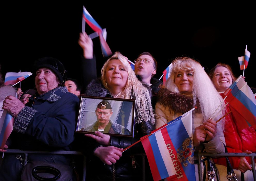 Foto: Una mujer sostiene un retrato de Putin en la ciudad de Sebastopol, en Crimea (Reuters).