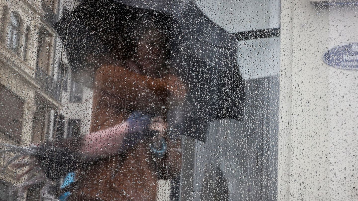 Una mujer camina bajo la lluvia este jueves en San Sebastián. (EFE/Javier Etxezarreta)