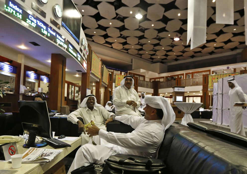 Foto: Inversores ríen mientras comentan las cotizaciones en la Bolsa de Dubái, en Emiratos (Reuters).