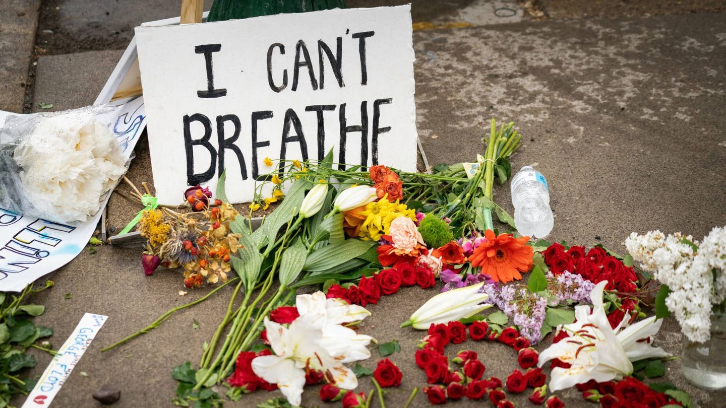 Flores y una pancarta en el lugar del asesinato de George Floyd. (Wikipedia)