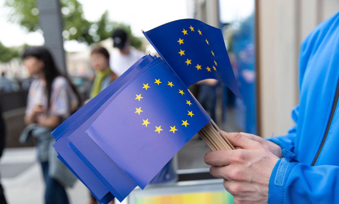 Un hombre sujeta banderas europeas en Berlín. (Reuters)