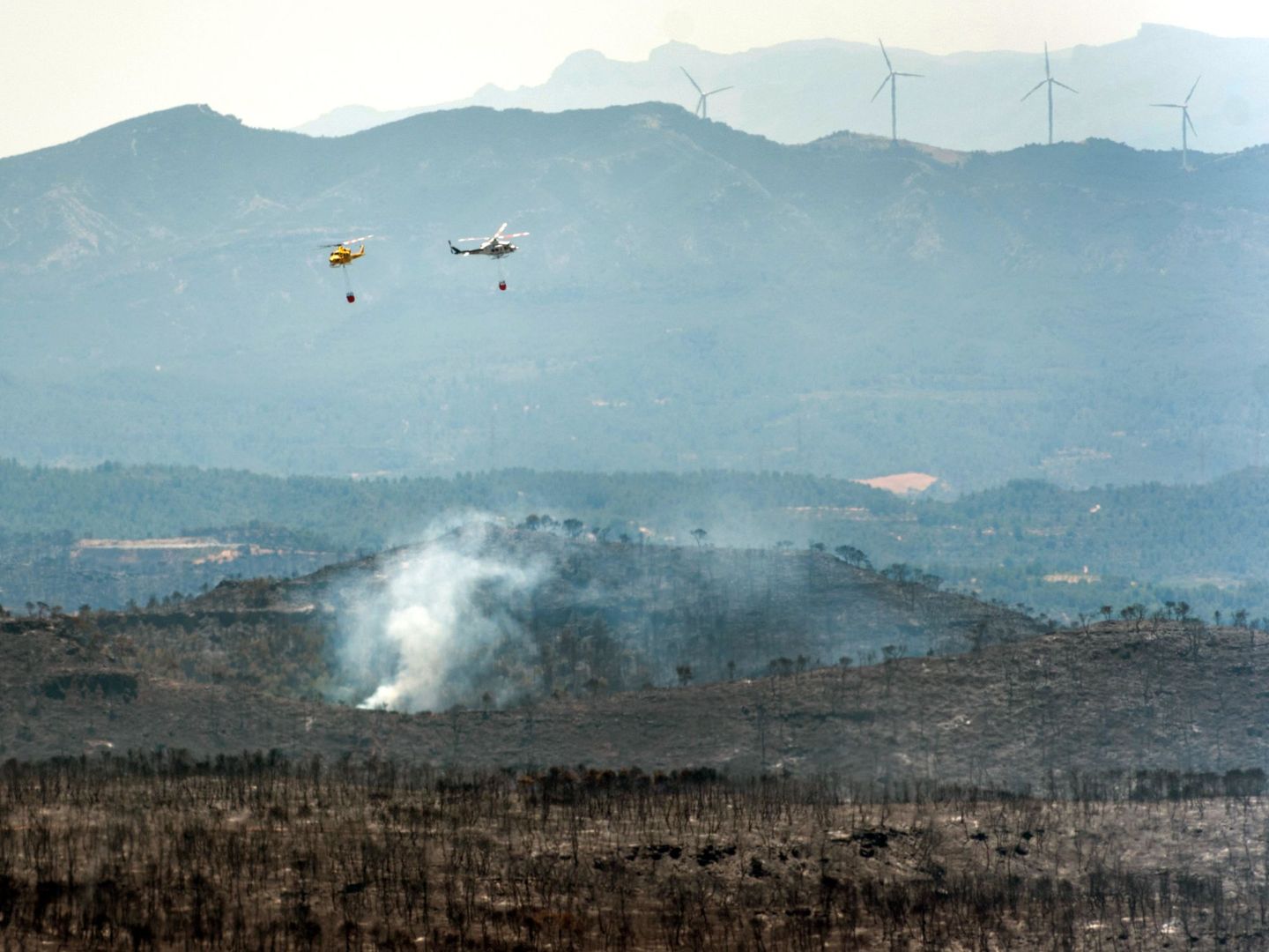Unos helicópteros trabajan en las tareas de extinción del incendio de la Ribera d'Ebre. (Efe)