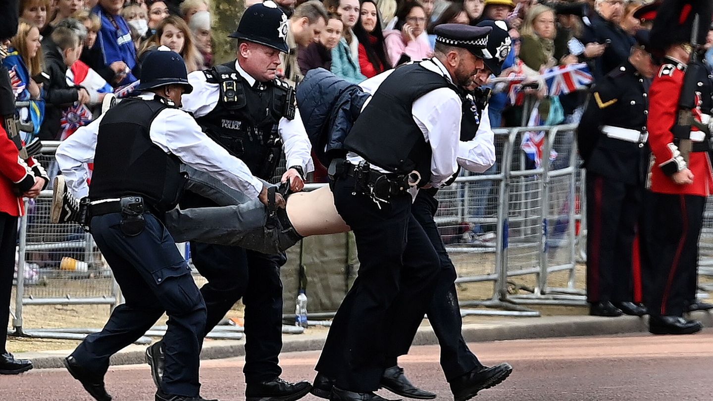 La policía retira a un hombre que protestaba por la celebración del jubileo. (EFE/Andy Rain)