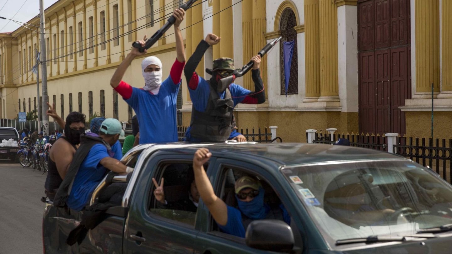 Personas con la cara tapada que apoyan a Ortega vigilan las calles de Masaya. (EFE)