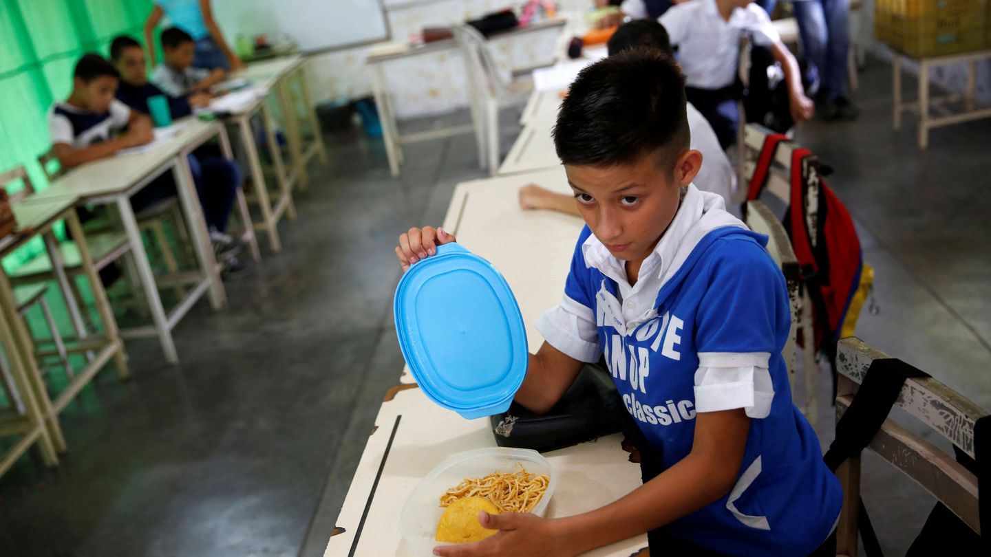 Un niño abre la comida que trae de casa en una escuela estatal en La Fría, Venezuela, el 2 de junio de 2016 (Reuters)