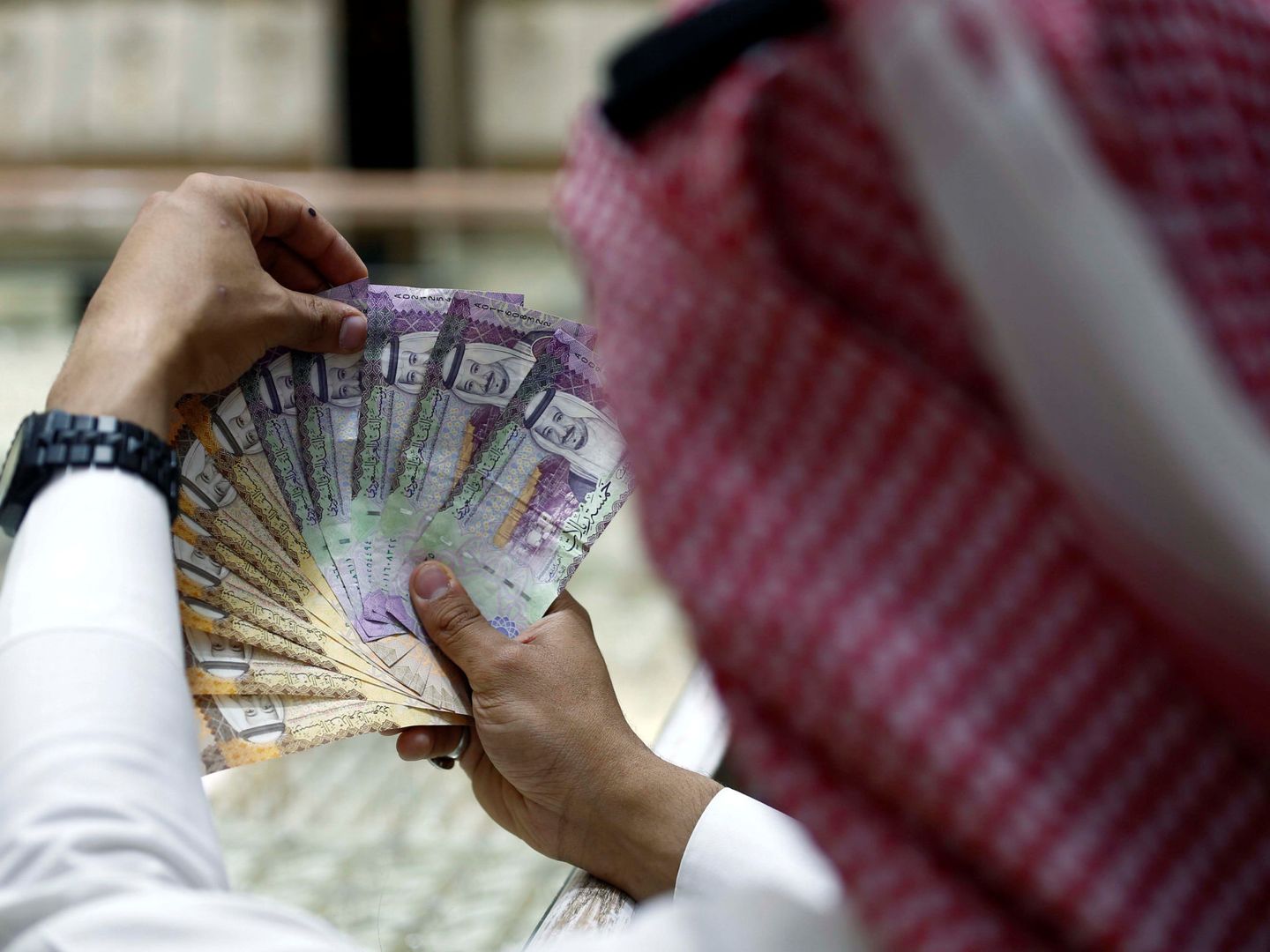 Un cambista saudí exhibe billetes en una casa de cambio en Riad, el 27 de julio de 2017. (Reuters)