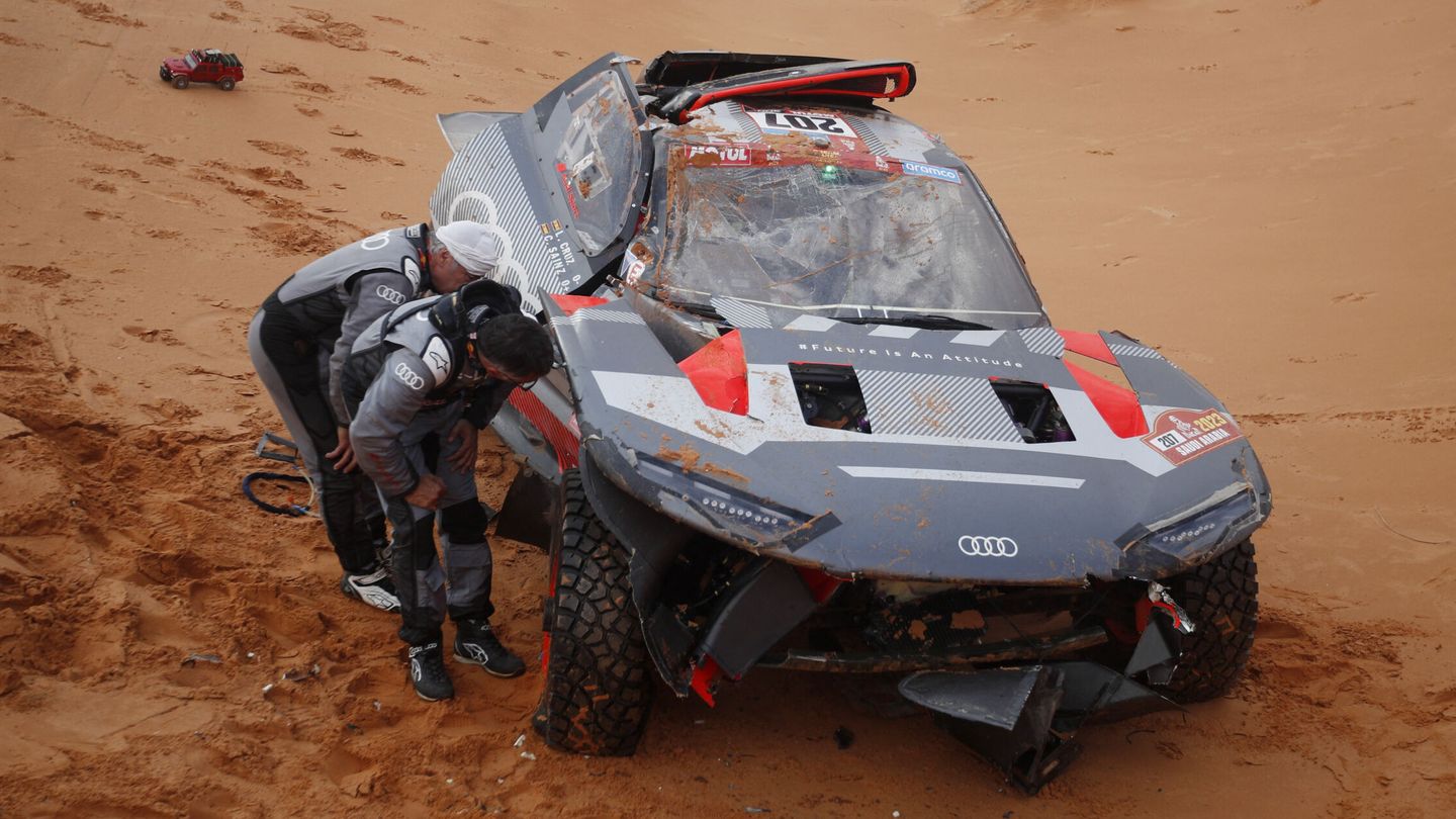 Carlos Sainz y Lucas Cruz, inspeccionando el e-tron e2 después del accidente del Dakar. (Reuters/Hamad I Mohammed)