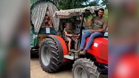 Un alcalde en el capó de un tractor con un vaso en la mano y su hijo menor conduciendo: polémica romería en Málaga