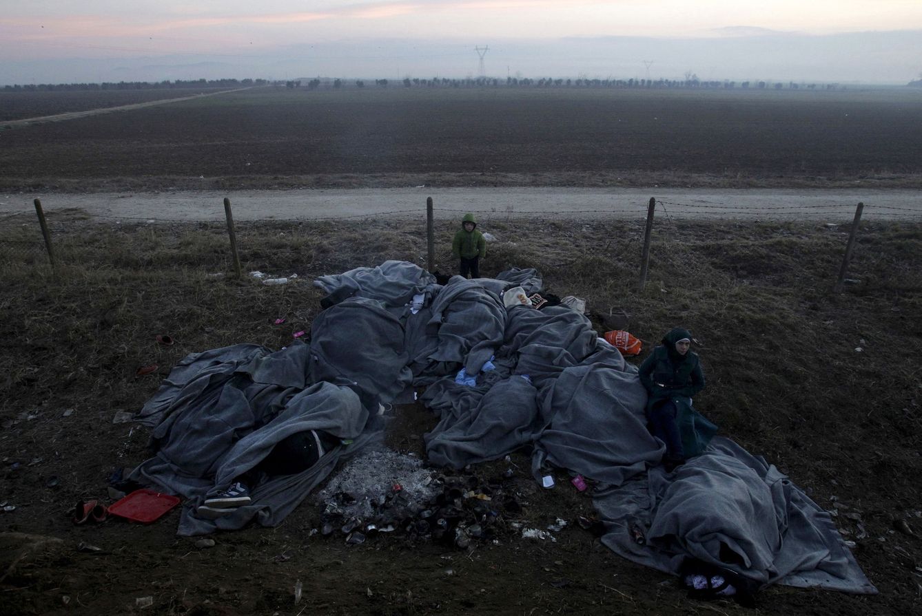 Refugiados y migrantes duermen cubiertos por mantas en la frontera entre Grecia y Macedonia, cerca de Idomeni, el 28 denero de 2016. (Reuters)